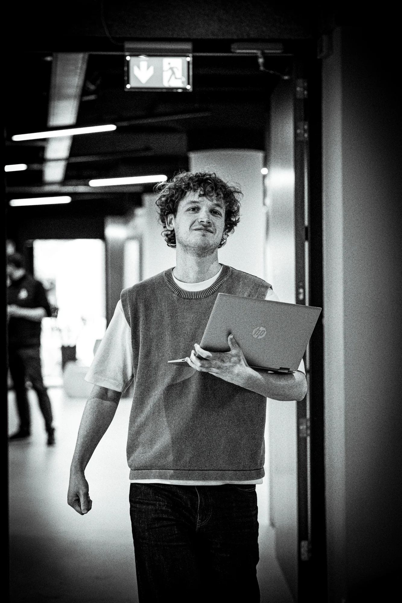 Engineer loopt met laptop door gang